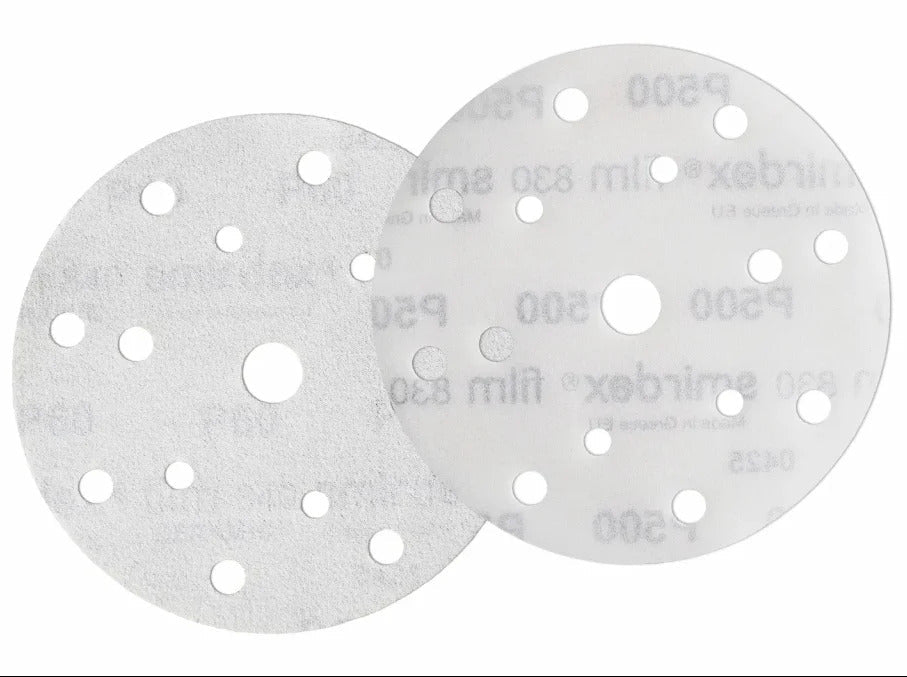 Two sanding discs with multiple holes on a white background