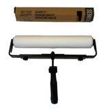 Roller with black handle and white roller sleeve on a white surface, with packaging in the background.