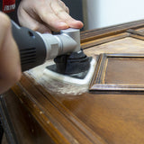 Person using a sander on a wooden surface