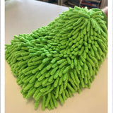 Green microfiber cleaning pad on a surface with a blurred background
