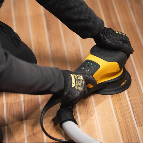 Person using a Mirka ROS  power sander on a wooden floor.