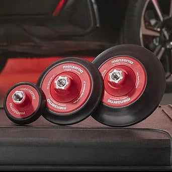 Black car with red accents and Menzerna products on a wooden floor.