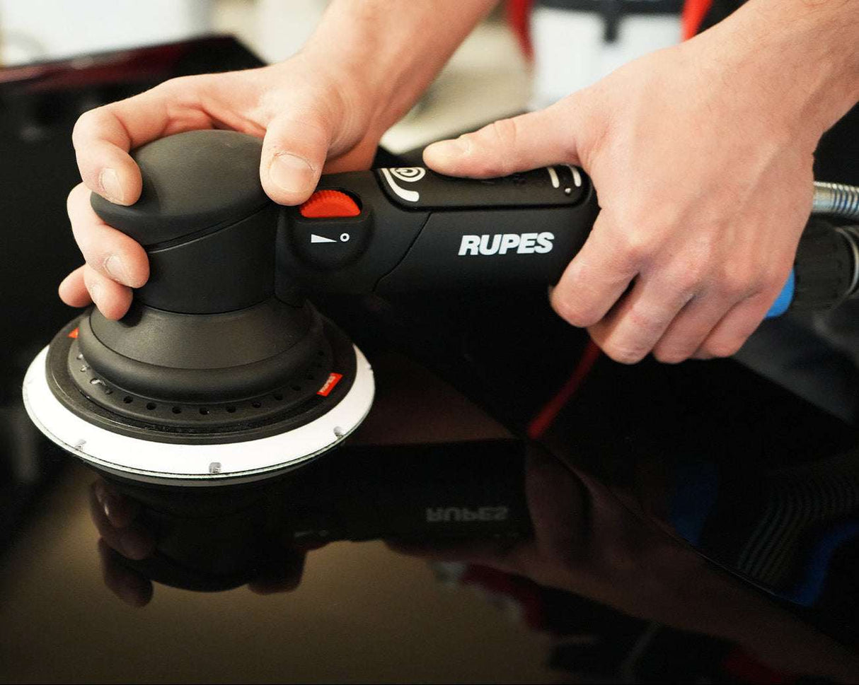 Person using a Rupes sander on a car surface