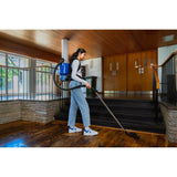Person using a vacuum cleaner on a wooden floor in a home setting